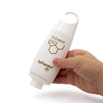 Bienenprodukte Shop ApiSupreme Duschgel für Damen in weißer Flasche mit praktischem Hängeverschluss in einer Hand